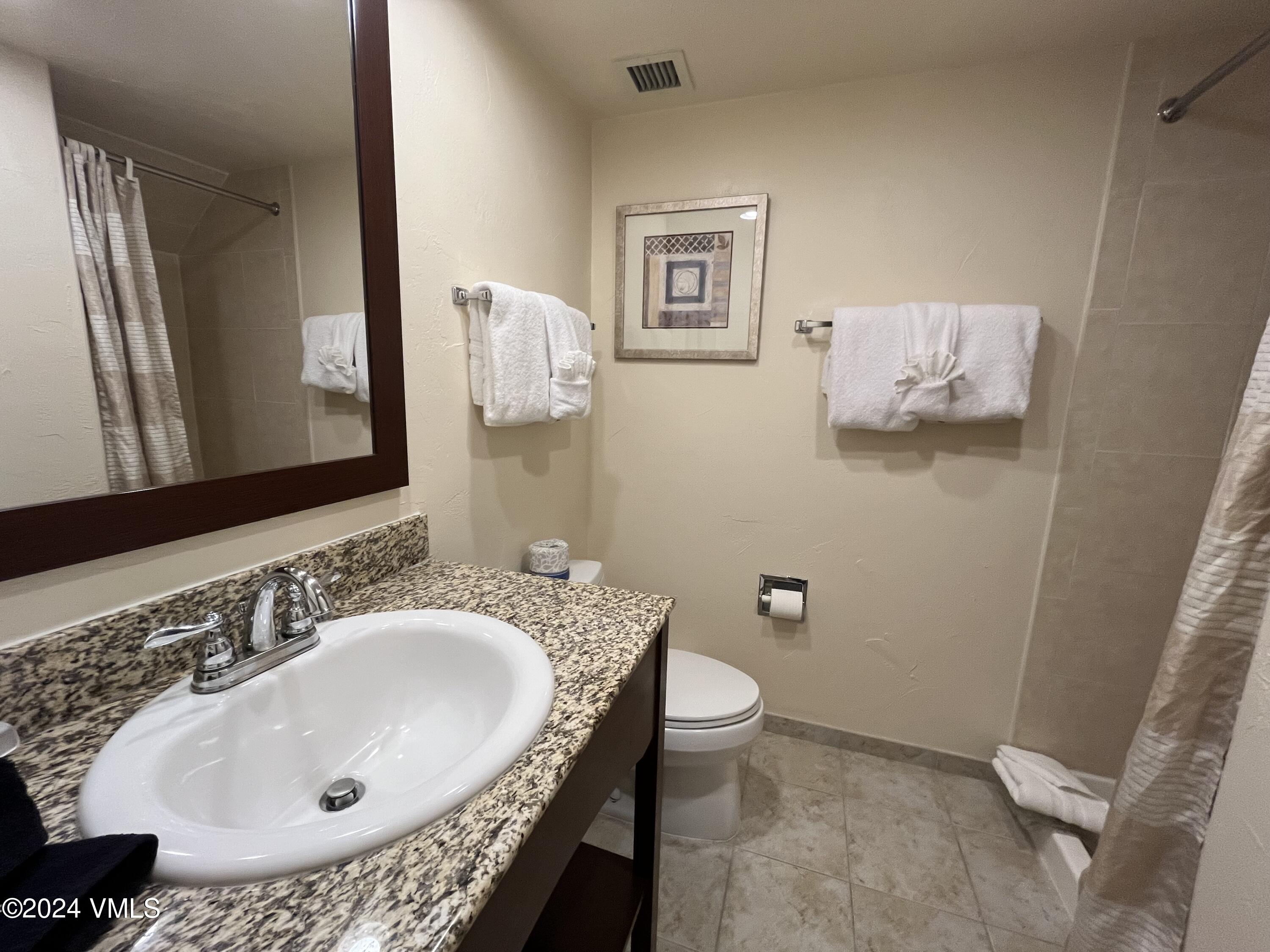 1020 Vail View Drive, Unit 340222 Vail, CO 81657 - Photo 20 of 32 a bathroom with a granite countertop toilet sink and mirror