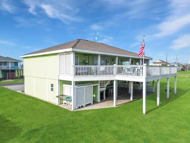 a view of house with a big yard and large trees