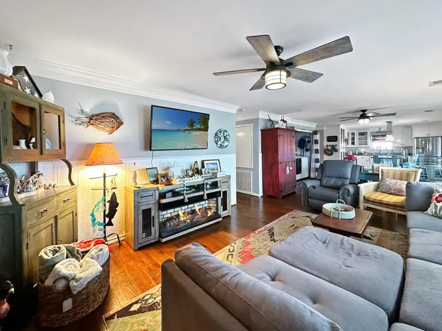 a living room with furniture kitchen view and a window