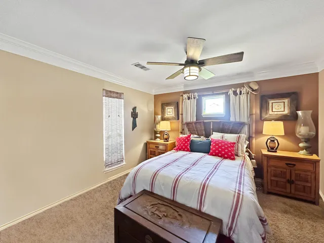 a bedroom with a bed a dresser next to a window