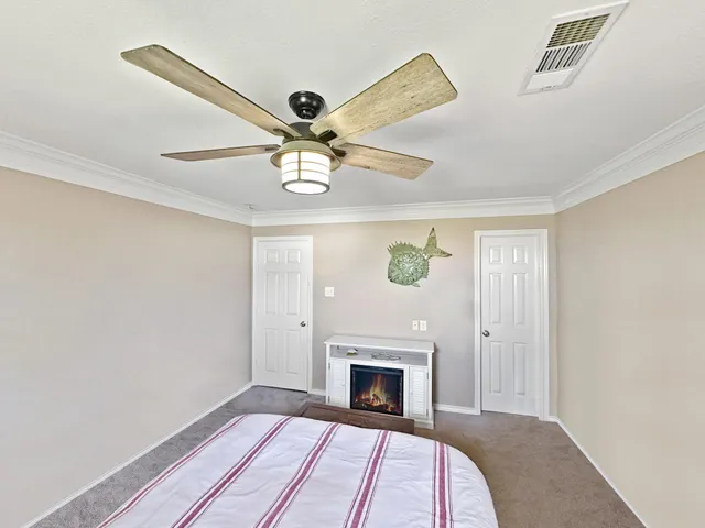 a view of a livingroom with a fireplace a ceiling fan and wooden floor
