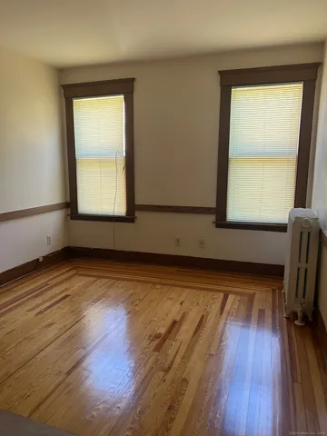 a view of a room with wooden floor and a window