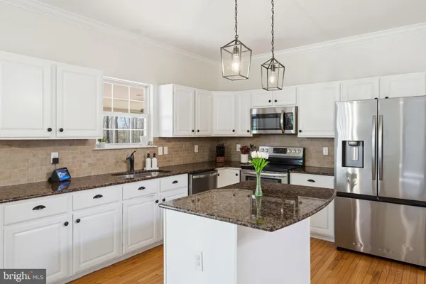 a kitchen with stainless steel appliances granite countertop a kitchen island a stove and a cabinets