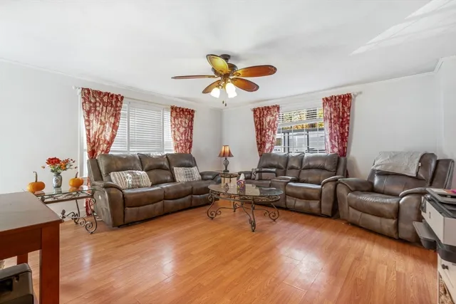 a living room with furniture a ceiling fan and a rug