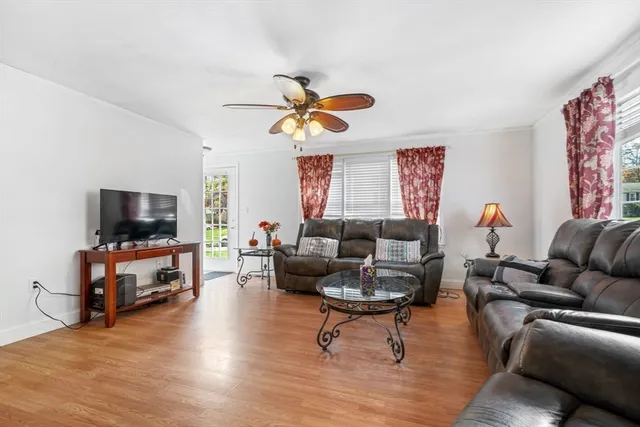 a living room with furniture a flat screen tv and kitchen view