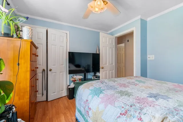 a bedroom with a bed and a flat tv screen on dresser