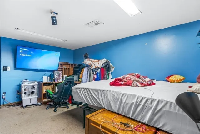 a bedroom with a bed a table and workspace