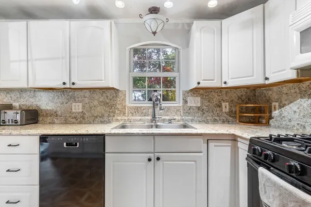 a kitchen with stainless steel appliances granite countertop a sink stove and cabinets