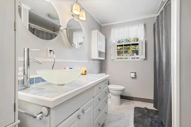 a bathroom with a sink a toilet and a mirror