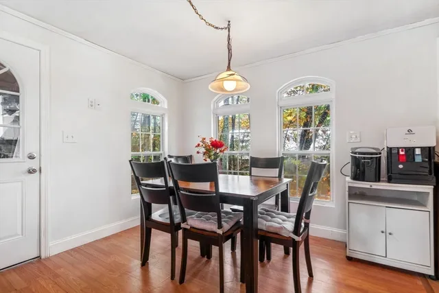 a view of a dining room with furniture a chandelier and wooden floor