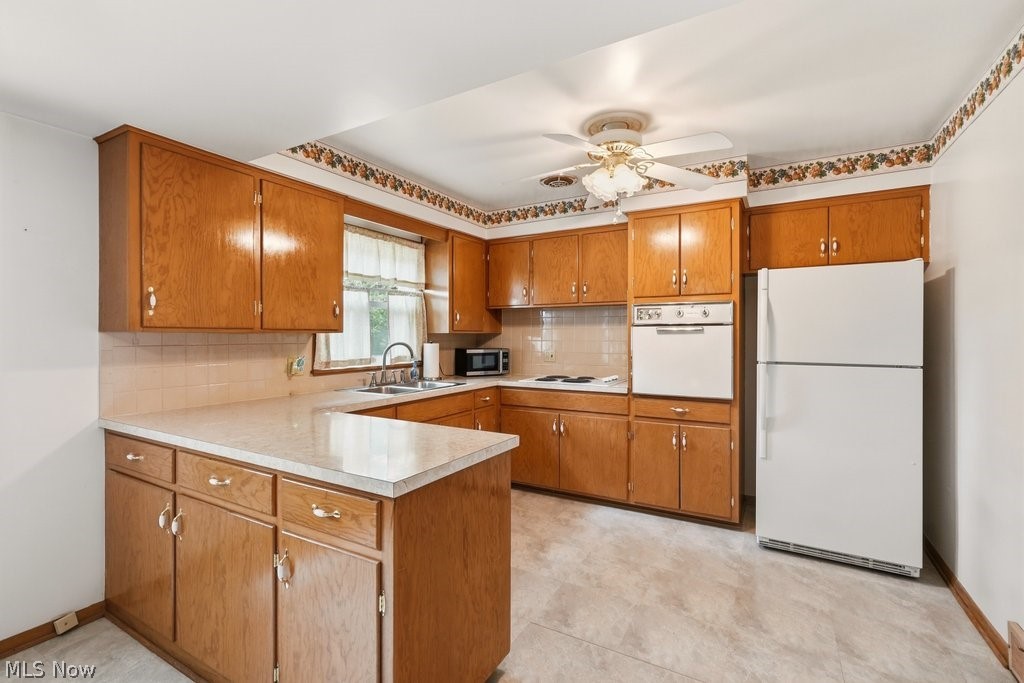161 Pinehurst Road Munroe Falls, OH 44262 - Photo 11 of 40 Kitchen featuring abundant wood cabinetry, laminate countertops, built-in oven, and a double basin sink with a window above