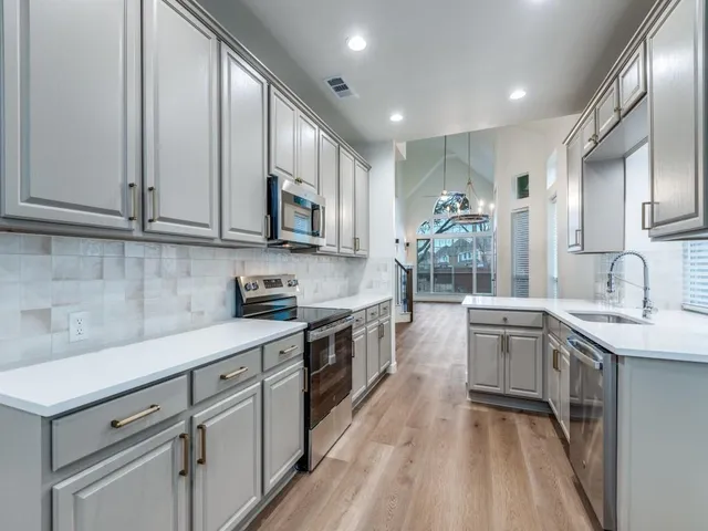 a kitchen with stainless steel appliances granite countertop a sink stove and cabinets
