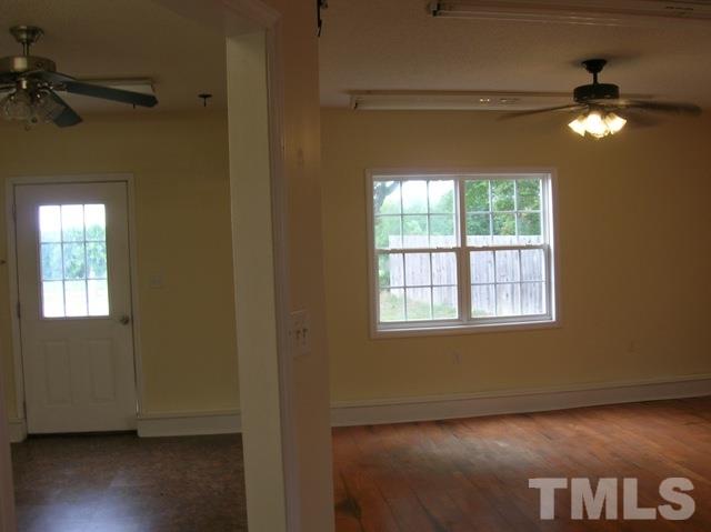 2695 Highway 42 Willow Spring, NC 27592 - Photo 16 of 22 a view of an empty room with a window and wooden floor