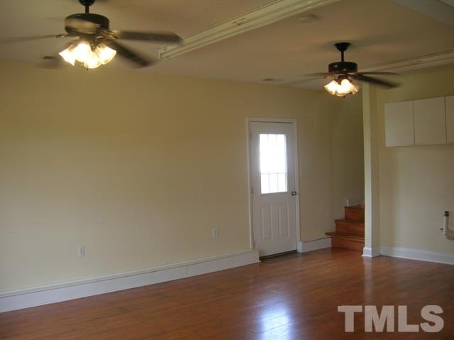 2695 Highway 42 Willow Spring, NC 27592 - Photo 18 of 22 an empty room with wooden floor chandelier fan and windows