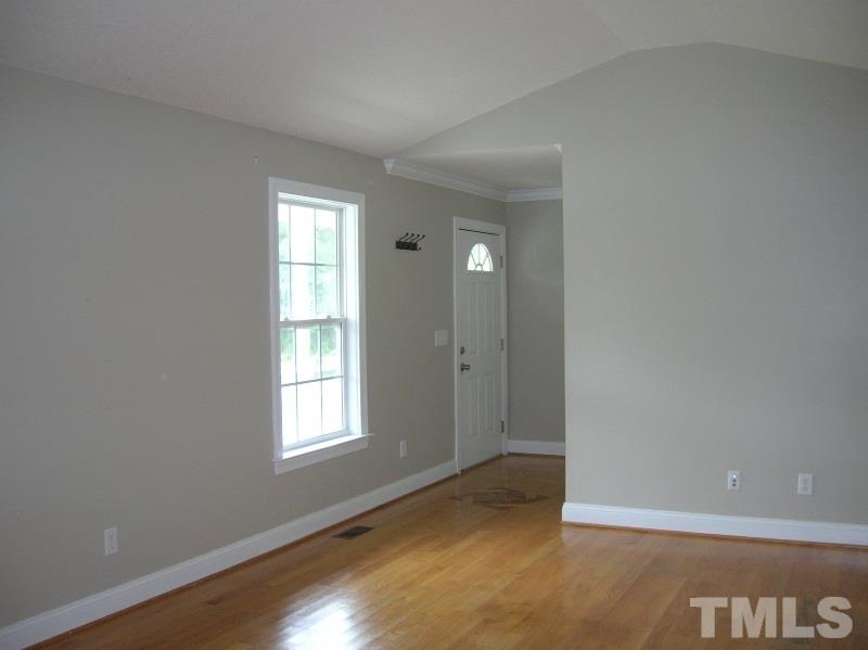 2695 Highway 42 Willow Spring, NC 27592 - Photo 19 of 22 an empty room with wooden floor and windows