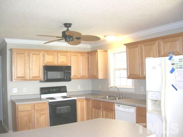 2695 Highway 42 Willow Spring, NC 27592 - Photo 4 of 22 a kitchen with a refrigerator a stove a sink and a window