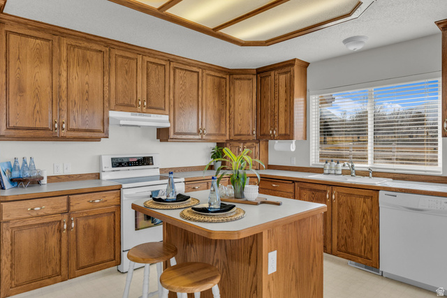 1060 West 2620th Street South Mapleton, UT 84664 - Photo 16 of 87 Kitchen featuring white appliances, wood finish cabinetry, light floors, a kitchen breakfast bar, and a center island