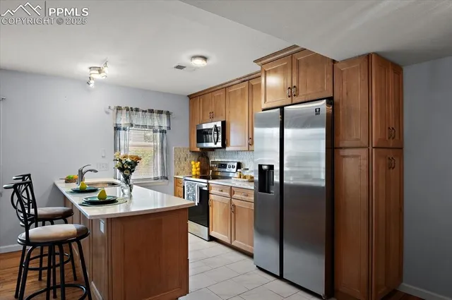 a kitchen with stainless steel appliances granite countertop a refrigerator and a stove top oven