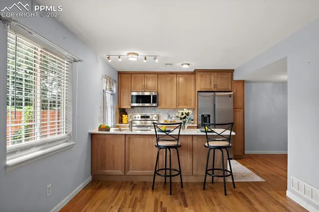 a view of a livingroom with wooden floor a fireplace and entryway