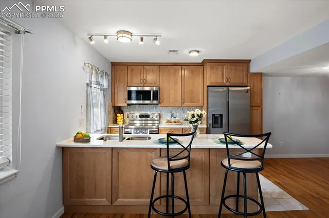 a kitchen with stainless steel appliances a refrigerator and microwave