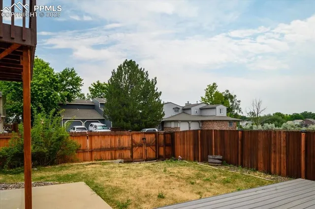 a view of backyard with small cabin and wooden fence