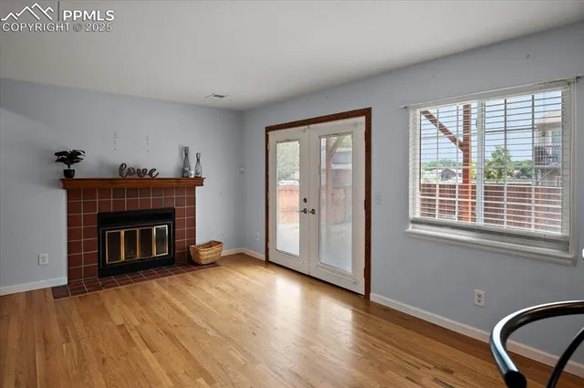 wooden floor fireplace and windows in an empty room