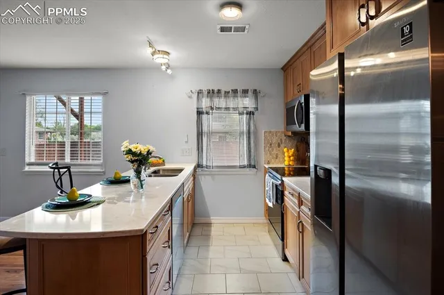 a kitchen with kitchen island a counter top space appliances and a window