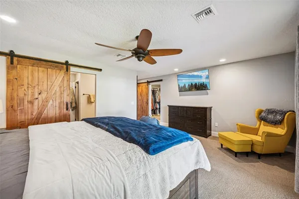 a bedroom with a bed a couch and a window