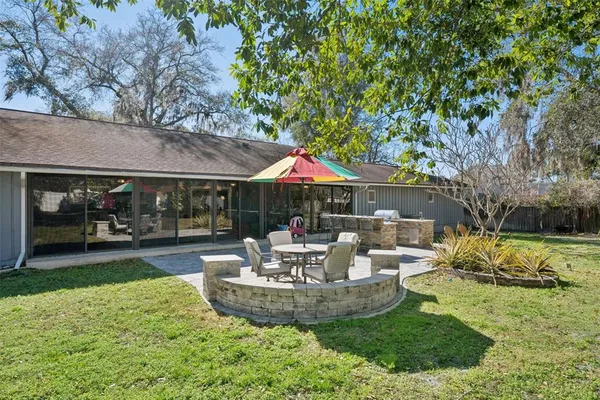 a view of a house with backyard sitting area and garden