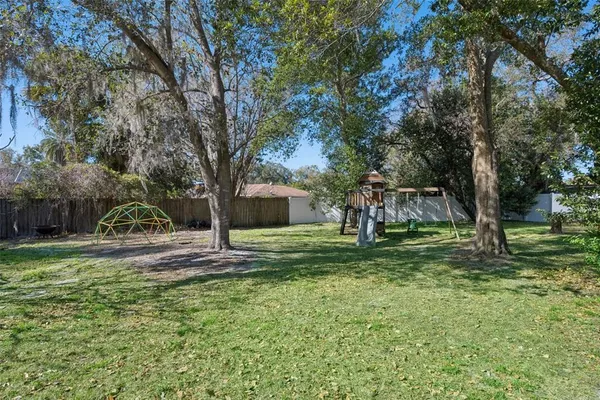a view of a yard with plants and trees