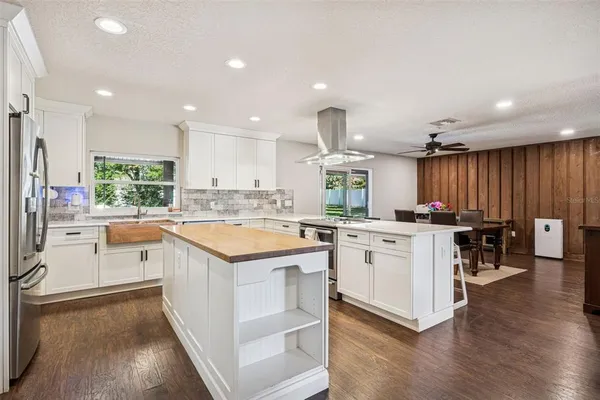 a kitchen with a sink stove cabinets and wooden floor