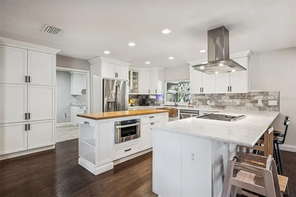 a kitchen with kitchen island a stove a sink and a refrigerator
