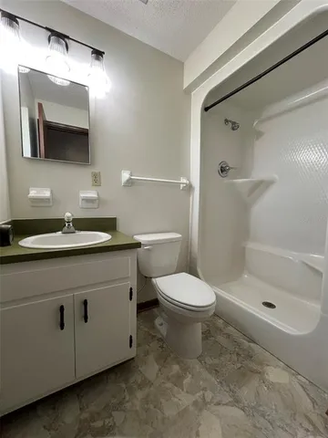 a bathroom with a sink a toilet and shower
