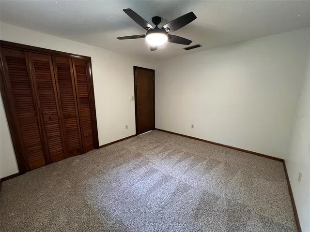 a view of an empty room with a ceiling fan