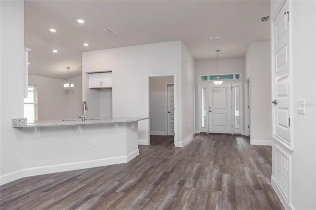 a kitchen with stainless steel appliances a sink and wooden floor