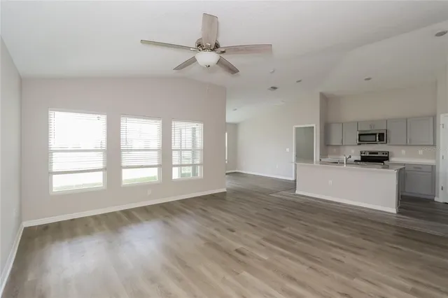 a view of an empty room with kitchen appliances and a window