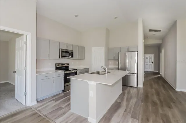 a kitchen with a sink a counter top space stainless steel appliances and cabinets