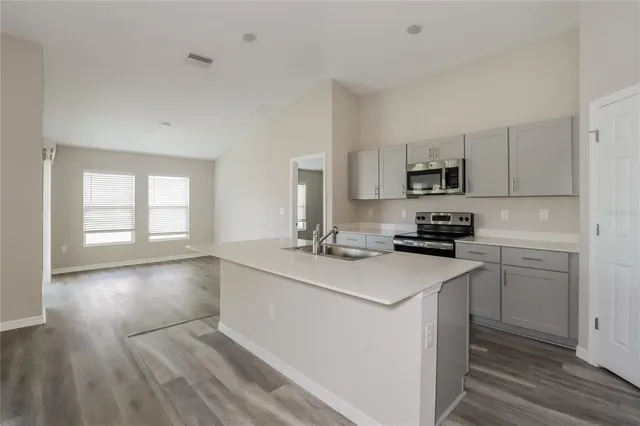 a kitchen with kitchen island white cabinets appliances and a window
