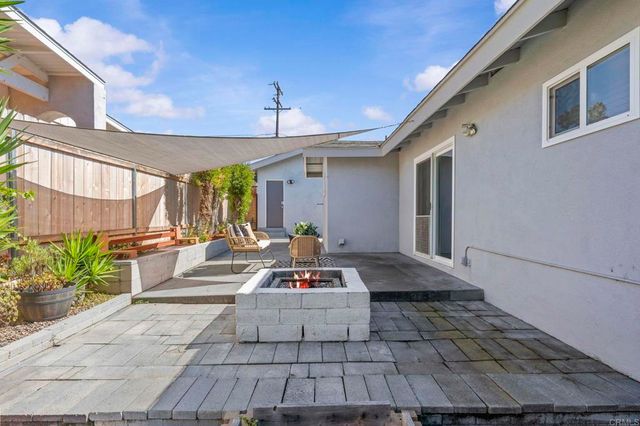 a view of a house with backyard and sitting area