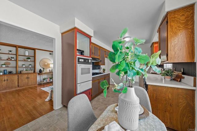 a kitchen with a stove a refrigerator and a chair