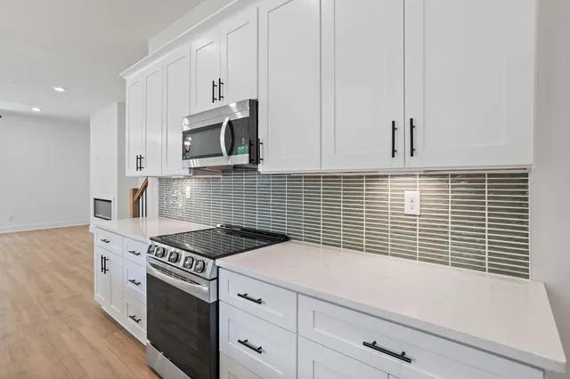 a kitchen with granite countertop a sink a stove and cabinets