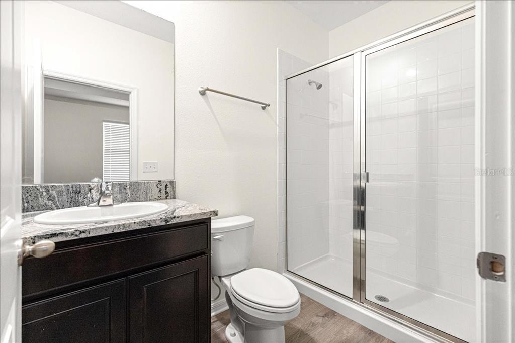 5851 Southwest 85th Place Ocala, FL 34476 - Photo 38 of 57 a bathroom with a granite countertop sink toilet and shower