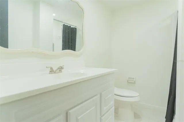 a bathroom with a sink a toilet and mirror