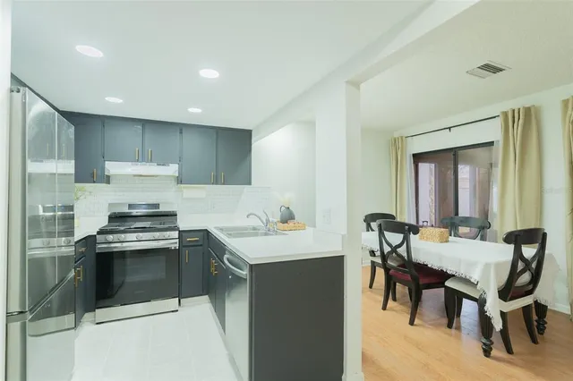 a kitchen with a stove a sink a dining table and chairs