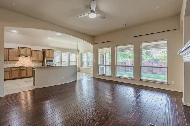 a view of a kitchen with a fridge wooden floor and a window