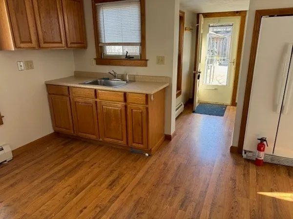 a view of a kitchen with wooden floor and cabinets
