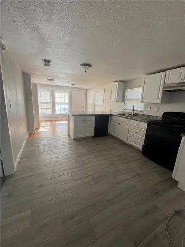 a large white kitchen with cabinets