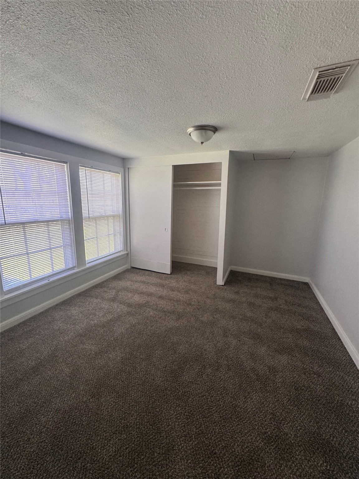 512 Rice Street Angleton, TX 77515 - Photo 9 of 12 an empty room with chandelier fan and windows
