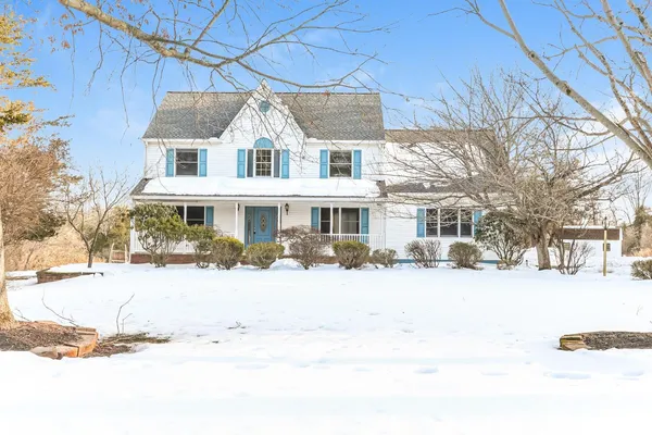 a front view of a house with a yard covered in snow