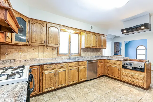 a kitchen with stainless steel appliances granite countertop a stove sink and cabinets